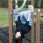 Zwei Jugendliche nutzen Reckstangen im Spielplatz für Turnübungen im Freien.