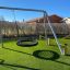Doppelte Nestschaukel (BNS 90 cm) aus Metall im Kinderspielplatz mit grünem Kunstrasen.