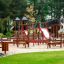 Spielplatz mit Fitness Anlage aus Holz und Kletterelementen im Park.