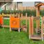 Trixie Barrierefreie Spielplatz mit Holzstruktur und bunten Spielelementen für Kinder, rollstuhlgäng