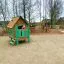 Brittas Spielhaus Holz-Spielhaus mit grünem Zaun auf Spielplatz
