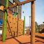 Spillikins Klettergerüst mit Kletterwand und Ringelemente auf einem modernen Spielplatz.