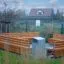 Ryga Deco Bank mit Rückenlehne aus Holz und Metall auf einem Spielplatz mit Umgebung.