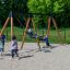 Schaukelrahmen für Nest-Sitz+1 Holz mit Metallrahmen auf Spielplatz mit Kindern am Spielen