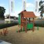 Kinderspielhaus Omas Spielhaus mit Kletterstämmen und Sanduntergrund auf Spielplatz.