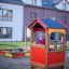Kinderspielfeld mit Spielhaus aus Holz und Kunststoff im Wohngebiet