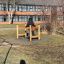 Person benutze das Spielplatzelement Kettenbrücke aus Holz.