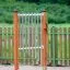 Röhrenglocken Spielgerät mit Holzpfosten auf Spielplatz im Sand.