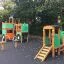 Großer Traktor Spielhaus mit Rutsche auf dem Spielplatz aus Holz und Grün