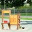 Marktstand II Spielhaus mit Holzstruktur und gelben Spielpaneelen für Kinder auf dem Spielplatz.