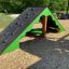 Spielplatzgerät Zelt Klettergerüst mit Kletterwand und Unterstand aus Holz und grünem Rahmen.