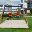 Doppel Schaukel: Babysitz und TS-Sitz mit Holzrahmen und Sandunterlage für Spielplatz.