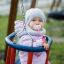 Doppel Schaukel: Kleinkind im sicheren Baby Schaukel mit Schnuller auf Spielplatz