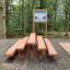 Treppe Holzspielplatz Sitzbänke im Wald mit Informationstafel
