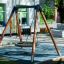 Nestschaukel (BNS 120 cm) aus Holz und Metall im Spielplatz mit Gummimatte