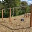 Schaukelrahmen aus Robinienholz 2+Nest-Sitz auf Spielplatz mit Holzschnitzelboden