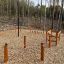 Kletternetz II Spielplatzausrüstung mit Kletternetz und robusten Holzpfosten im Waldgebiet.