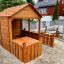 Spielhaus mit Zaun und Matschtisch aus Holz am Sandspielplatz