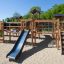 Windsor Spielanlage mit Rutschen aus Holz auf einem Sandspielplatz bei Sonnenschein