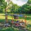 Outdoor Klassenraum Mit Holzbänken, Sonnenschutz und Tafel im grünen Park