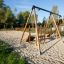 Doppelte Seilbahn mit Podesten aus Holz und Metall auf einem Sandplatz im Freien.