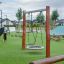 Nestschaukel Robinie (BNS 90 cm) Holzrahmen mit rundem Nestschaukel-Sitz auf Spielplatz mit Kunstras