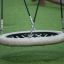 Nestschaukel Robinie (BNS 90 cm) aus Naturholz mit robustem Seilnetz auf Spielplatz-Grünfläche