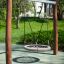 Nestschaukel Robinie (BNS 90 cm) mit rundem Sitz auf Spielplatz im Grünen.