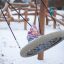 Nestschaukel Robinie (BNS 90 cm) mit Kind auf Schneespielplatz