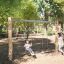 Natur Schaukel Eco Kinderschaukel aus Holz auf Spielplatz bei Sonnenschein