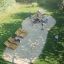 Tambora Spielhaus mit Rutsche Eco aus Holz im Garten mit Klettergerüst und Sitzbänken.