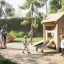 Tambora Spielhaus mit Rutsche Eco aus Holz auf Spielplatz mit Kindern