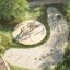Alstad Spielkombination mit Rutsche Eco auf einem Spielplatz im Park, umgeben von Bäumen und Grünflä