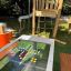 Hpl Bank & Spieltisch mit integriertem Glas-Spielbrett und bunten Spielfiguren, umgeben von Holzspie