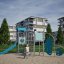 Spielanlage Köln mit blauen Kletter- und Rutschelementen auf einem Spielplatz in urbaner Umgebung