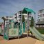 Festung mit Rutsche, kinderspielplatz mit grün-grauer rutsche und kletterelementen