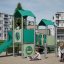 Bastei mit Rutsche Spielplatzgerät mit grüner Rutsche und überdachten Plattformen in Wohngebiet