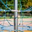Spinnennetz – Kletternetz mit blauem Seil und zentralem Stahlpfosten auf Spielplatz