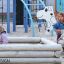 Sandkasten us Holz mit spezieller Designform und Spielplatzgerät im Hintergrund.