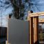 Piraten Basis Spielanlage mit Tunnel und Rutsche aus Holz mit schwarzen Paneelen im Spielplatz.