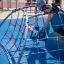 Kinder spielen auf dem Kleiner Bergsteiger Klettergerüst im Spielplatz.
