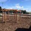 Yellowstone Klettergerüst aus Holz im Spielplatz bei sonnigem Wetter.