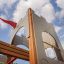 Kleine Schloßbrücke Spielturm mit Rutsche aus Holz und Metall bei klarem Himmel