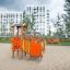 Smart Spielanlage mit Rutsche aus Holz und bunten Paneelen auf Sandfläche, geeignet für Kinder zum K