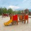 Rubik Spielanlage mit Rutsche und Kletterelemente us Holz und farbige Paneele im Sandspielplatz.