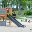 Klettergerüst mit Rutsche aus Holz auf einem Sandspielplatz im Park