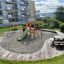 Kramladen Klettergerüst mit Rutsche auf Kinderspielplatz mit Schaukel und Picknicktisch