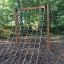 Schmetterling Kletternetz Groß an Holzrahmen im Spielplatz bei Wald.