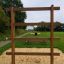 Holz-Große Leiter als Klettergerüst auf Sandspielplatz bei grünem Rasen.