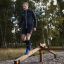 Mann trainiert Gleichgewicht auf einem hölzernen Balancierbalken im Outdoor-Spielplatz.